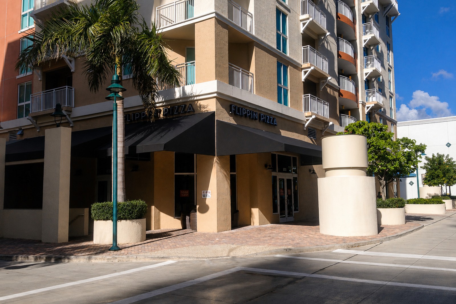 Black curved canopy wraps the corner of a multi-story residential tower in Coral Gables.